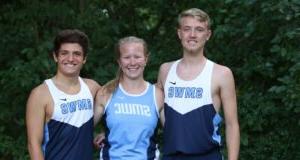 Two male and one female cross country students stand together smiling.